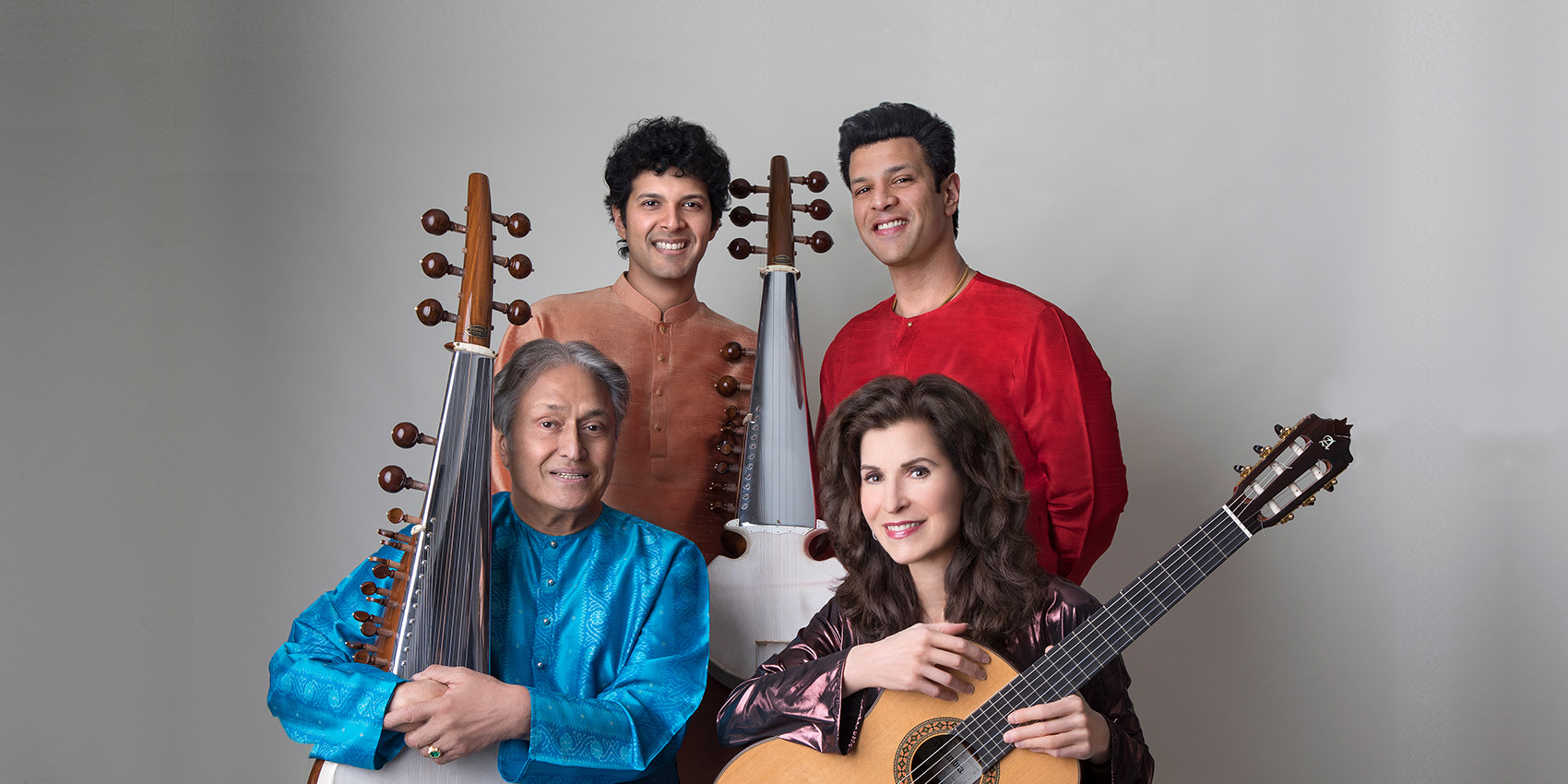 Four performers pose with their string instruments against a neutral background