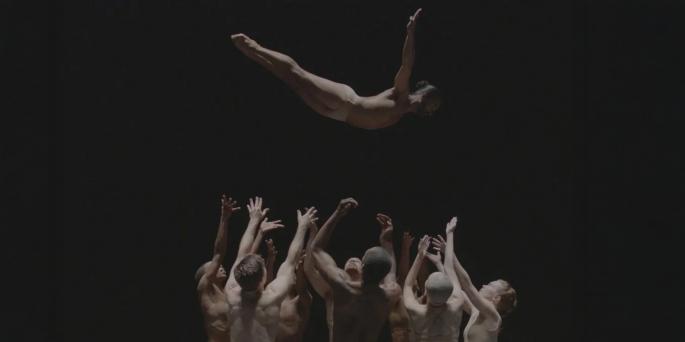 Group of dancers throw up another and wait to catch them