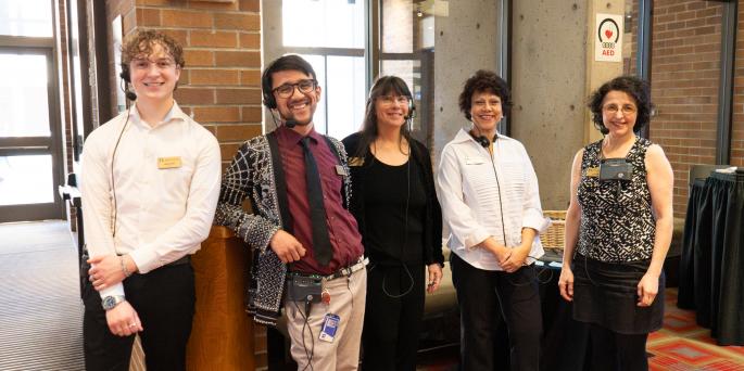5 front of house staff members stand in front of door
