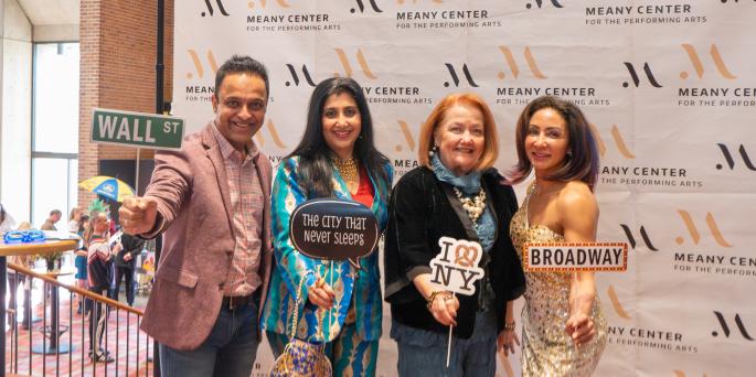Four people pose with New York props
