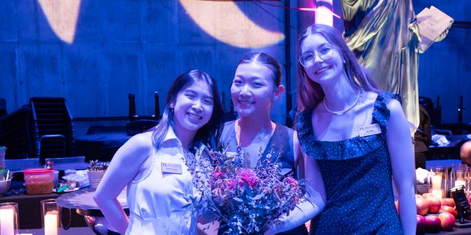 Three people in formal attire in blue light