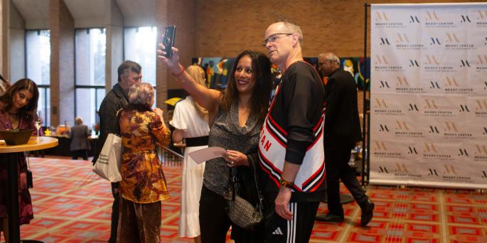 Two people stand in lobby taking selfie