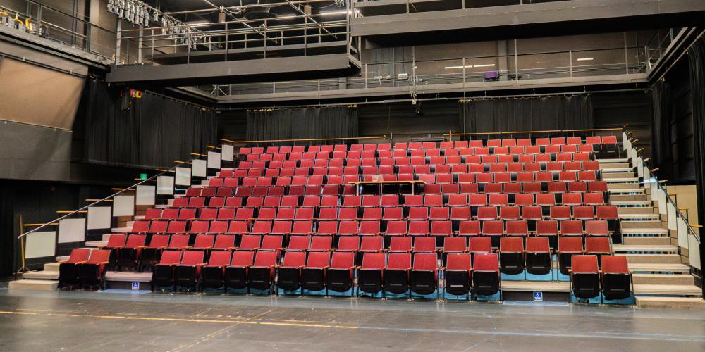 intimate theatre with empty red seats
