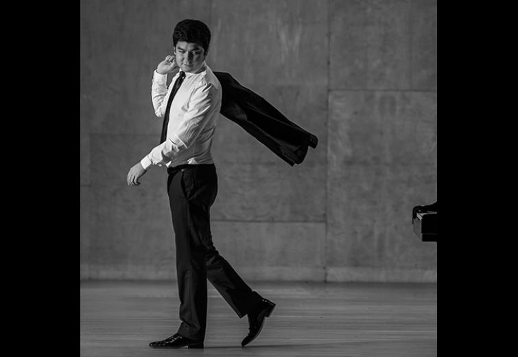 Black and white image of the performer throwing his jacket behind his shoulder