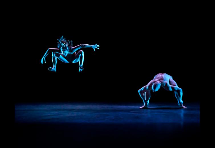 Two performers in dynamic poses on stage