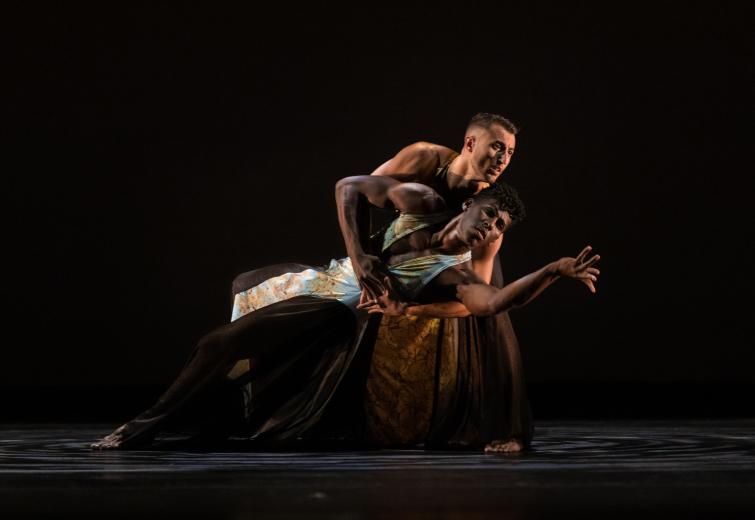 Two male dancers against a black background