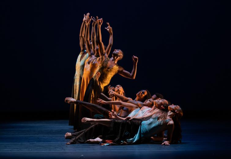 Eight male and female dancers standing and reclining