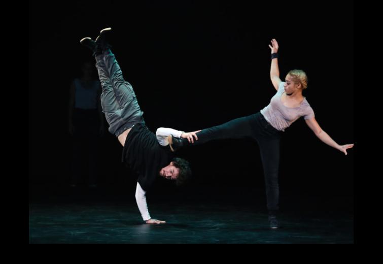 Two dancers in a dynamic pose on stage