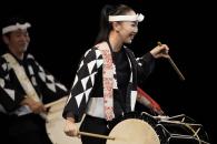 Two performers in traditional costumes with drums